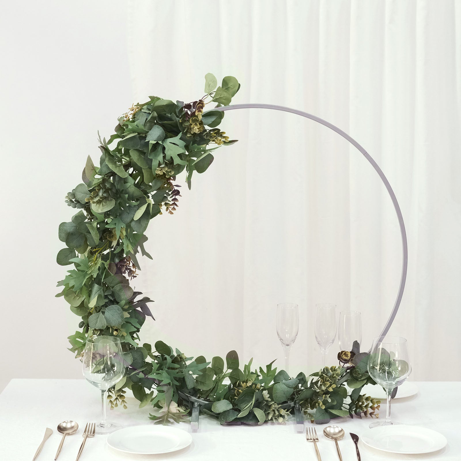 Silver metal round hoop wedding centerpiece with floral accents.