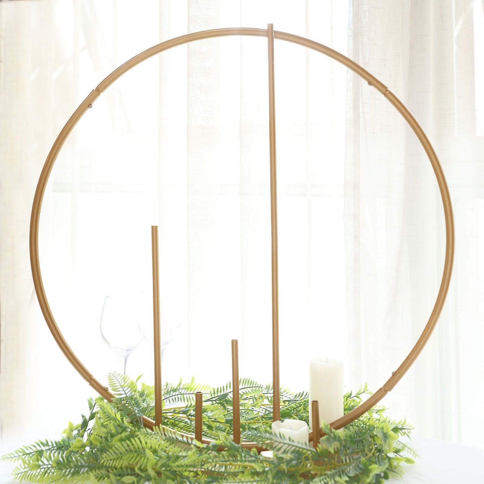 24" gold floral hoop wedding centerpiece with pillars and greenery.