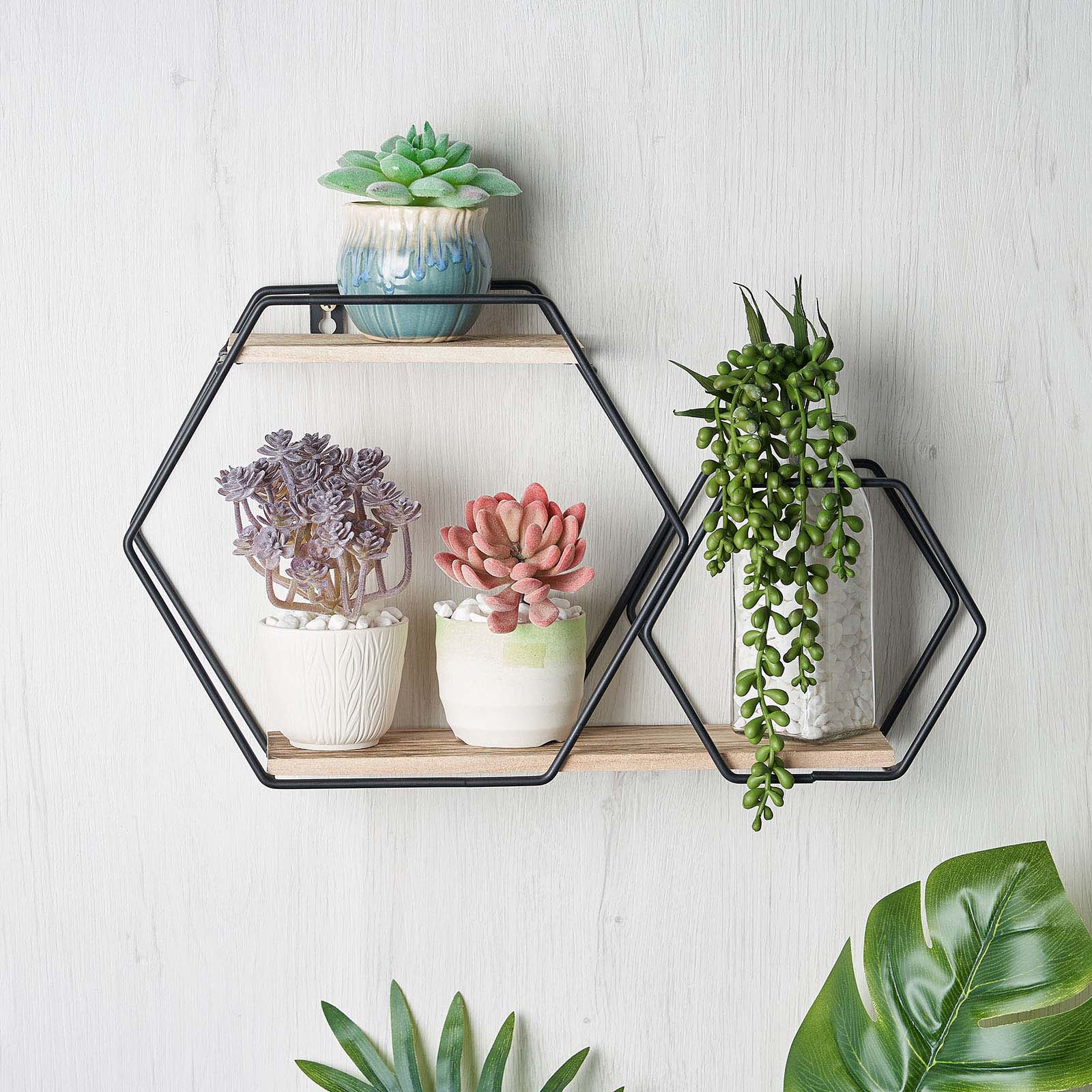 Black geometric 2-tier floating shelf with plants and decor.