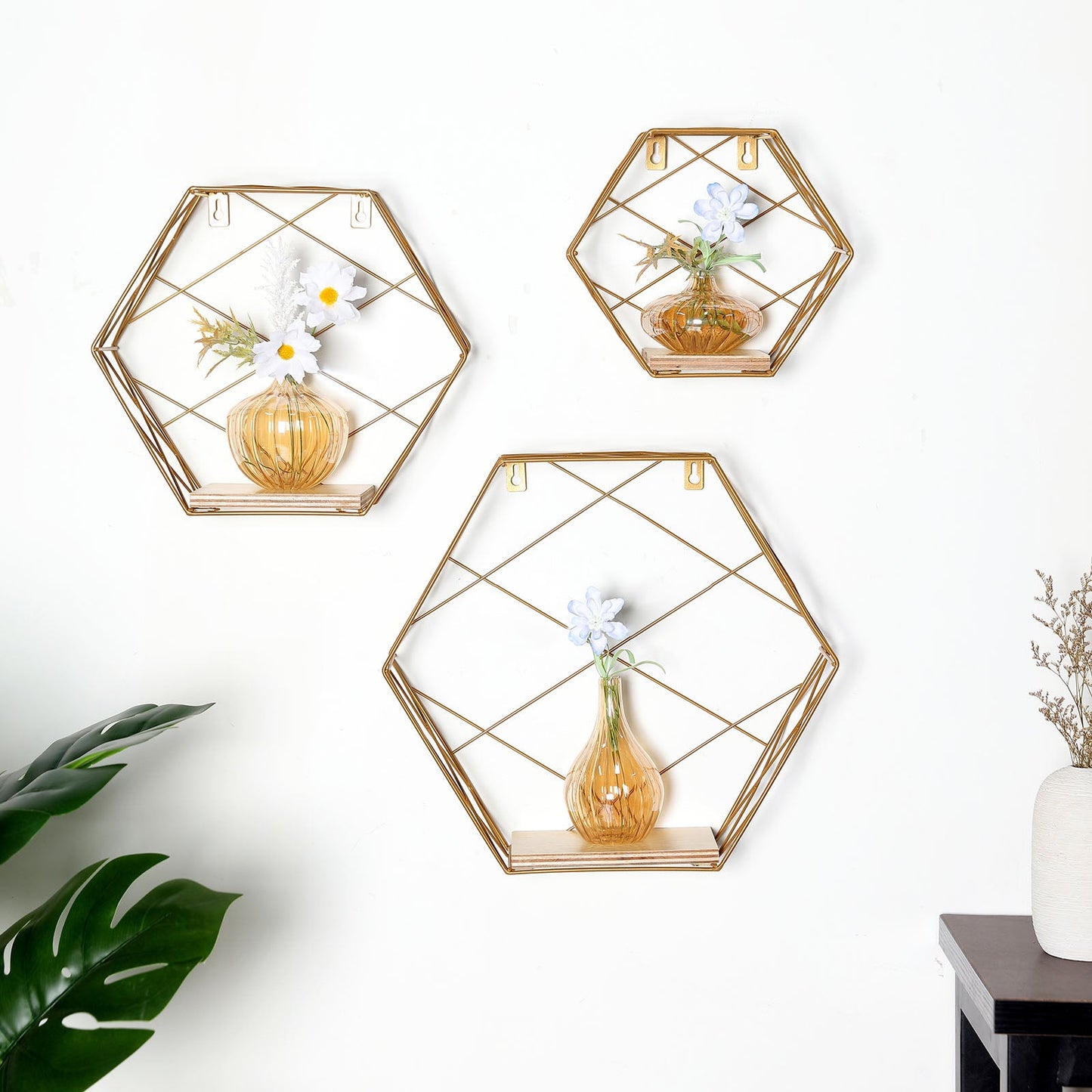 Gold hexagonal floating wall shelves with decorative vases and flowers.