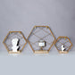 Gold hexagonal floating wall shelves with decorative items.