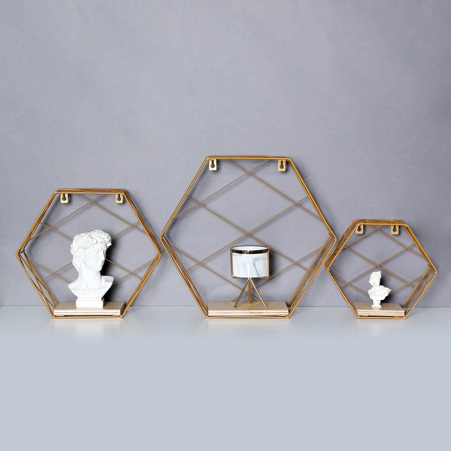 Gold hexagonal floating wall shelves with decorative items.
