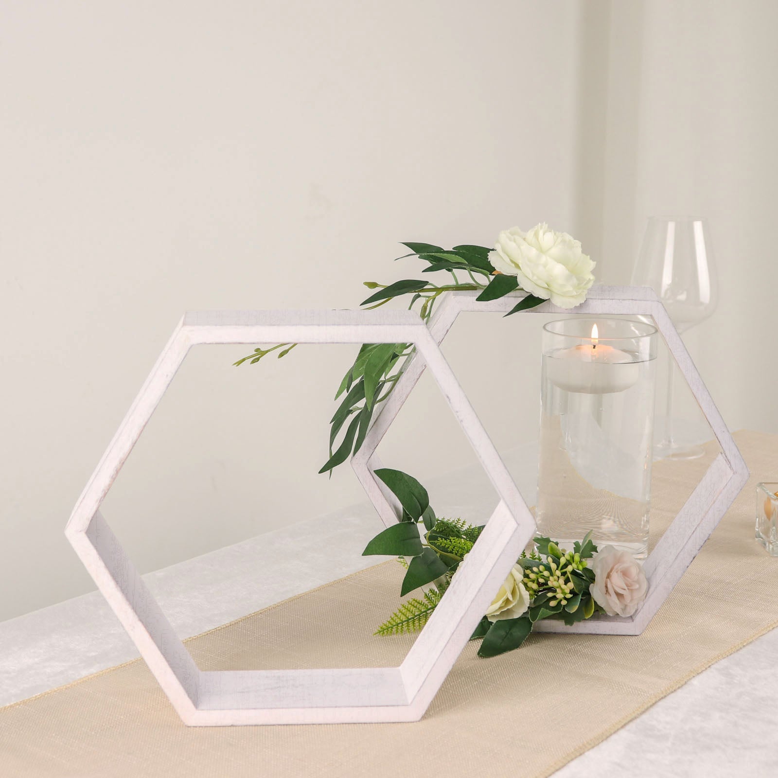 Whitewashed hexagon wood centerpieces with greenery and floral accents.
