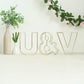 Gold wedding centerpiece decorative wire letter "U" on display.