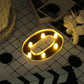 Gold 3D marquee number "0" with warm white LED lights.