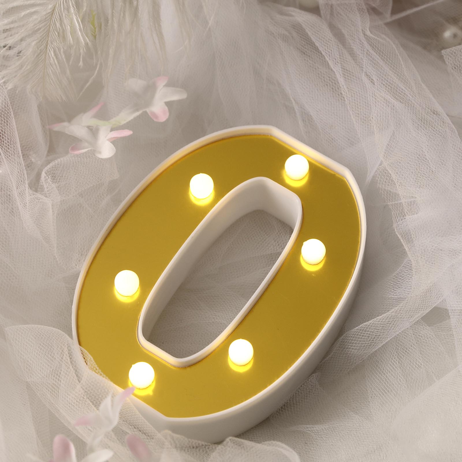 Gold 3D marquee number "0" with warm white LED lights.
