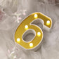 Gold 3D marquee number 6 with warm white LED lights.