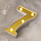 Gold 3D marquee number 7 with warm white LED lights.