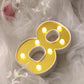 Gold 3D marquee number 8 with warm white LED lights.