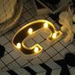Gold 3D marquee letter "C" with warm white LED lights.