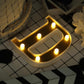 Gold 3D marquee letter "D" with warm white LED lights.
