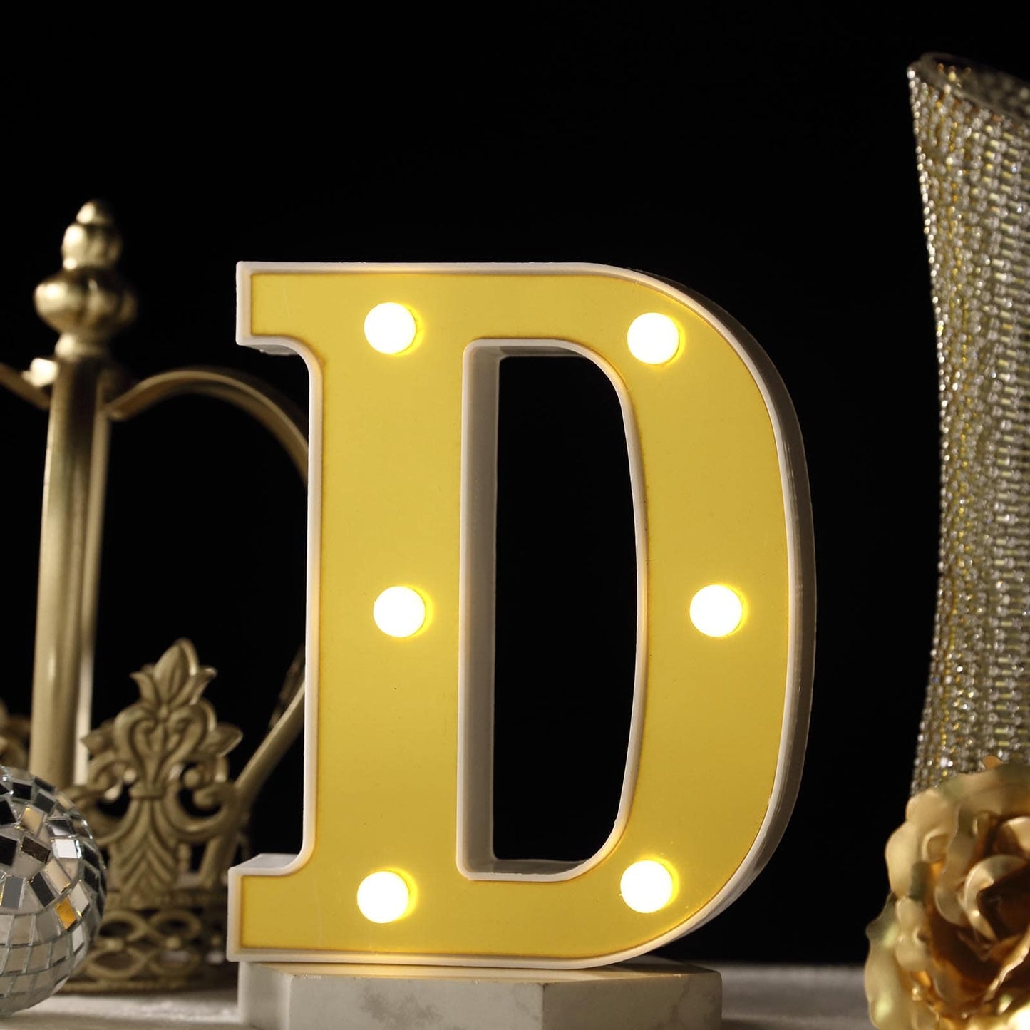 Gold 3D marquee letter "D" with warm white LED lights.