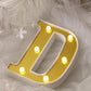 Gold 3D marquee letter "D" with warm white LED lights.