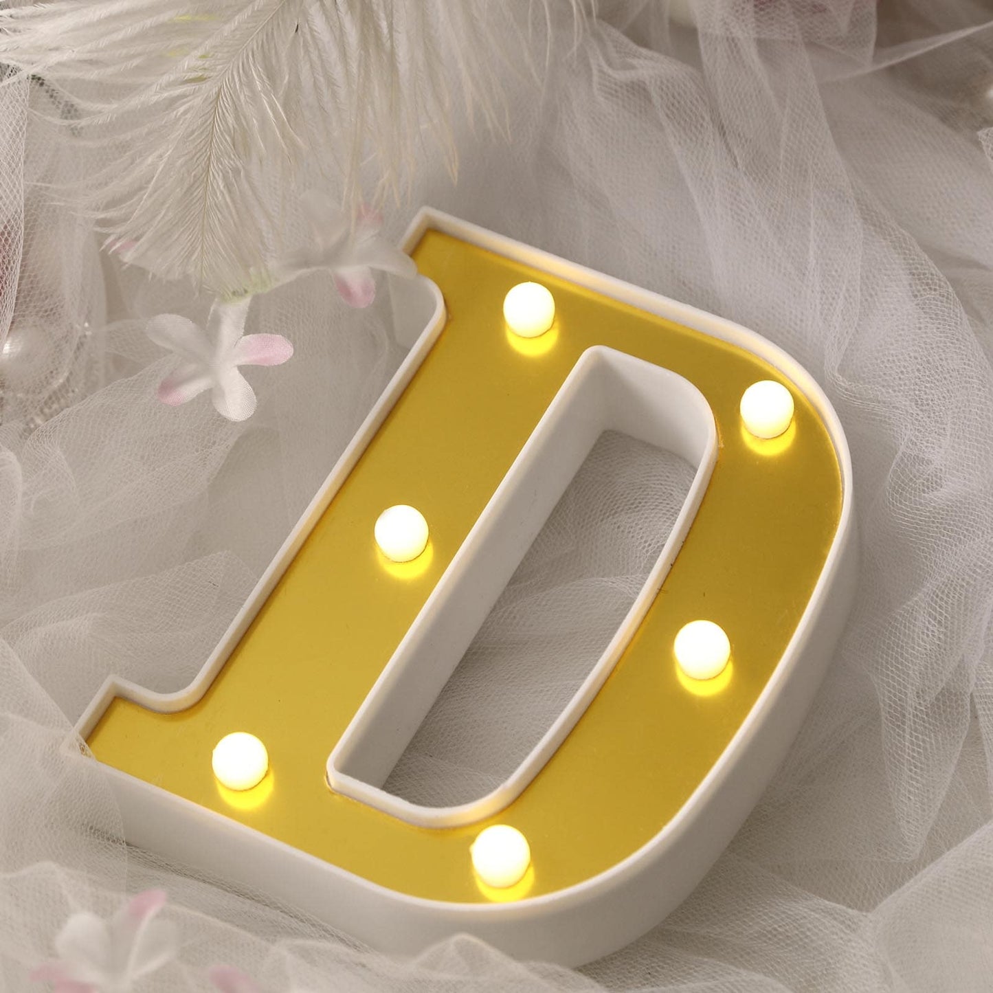 Gold 3D marquee letter "D" with warm white LED lights.