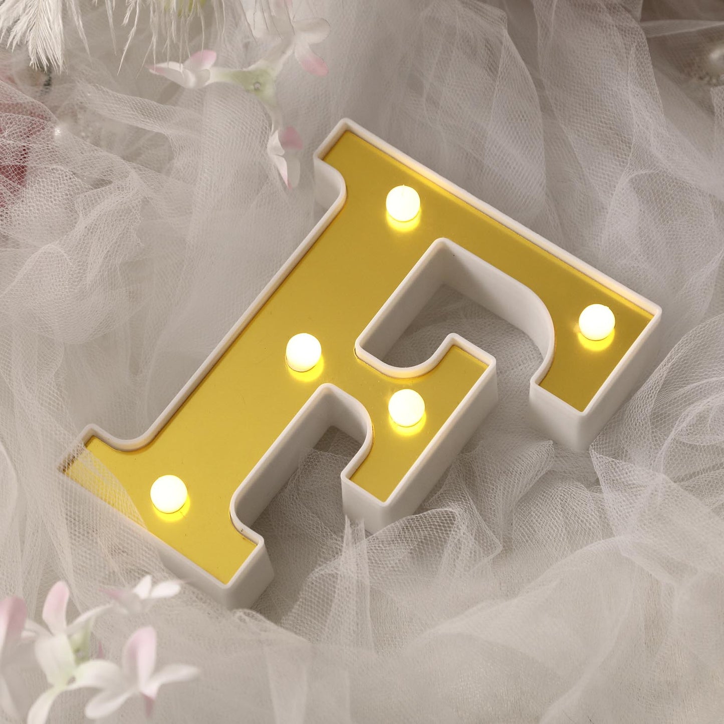 Gold 3D marquee letter "F" with warm white LED lights.