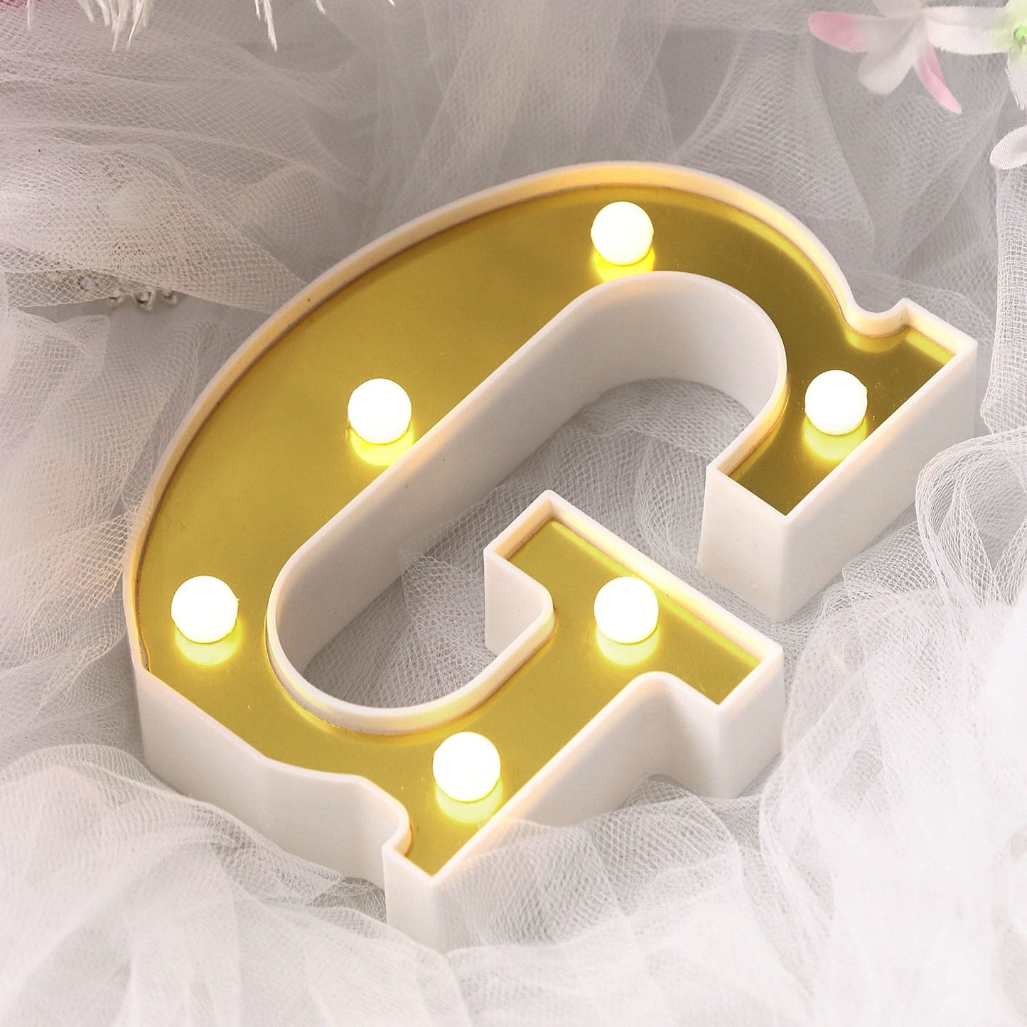 Gold 3D marquee letter 'G' with warm white LED lights.