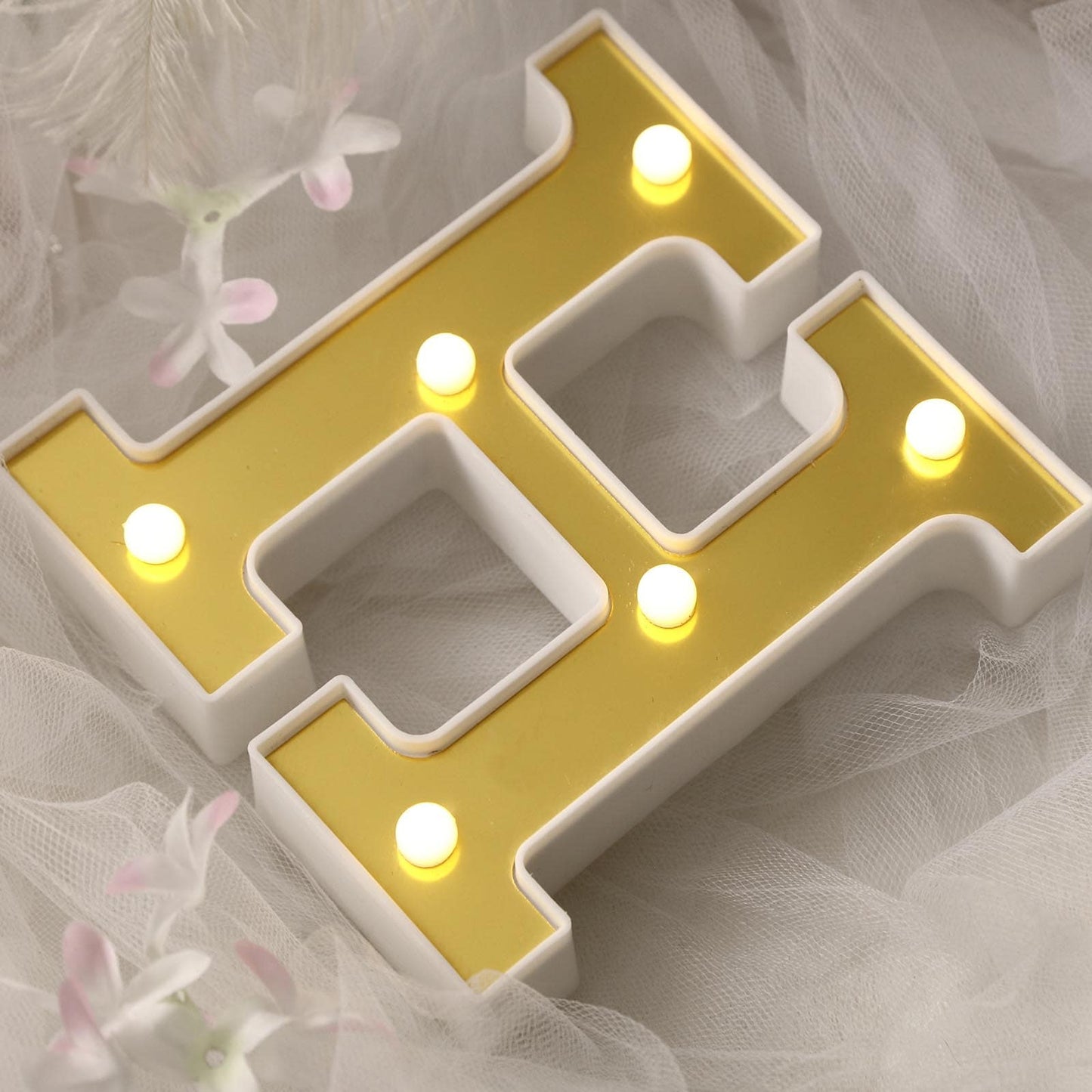 Gold 3D marquee letter "H" with warm white LED lights.