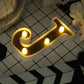 Gold 3D marquee letter "J" with warm white LED lights.