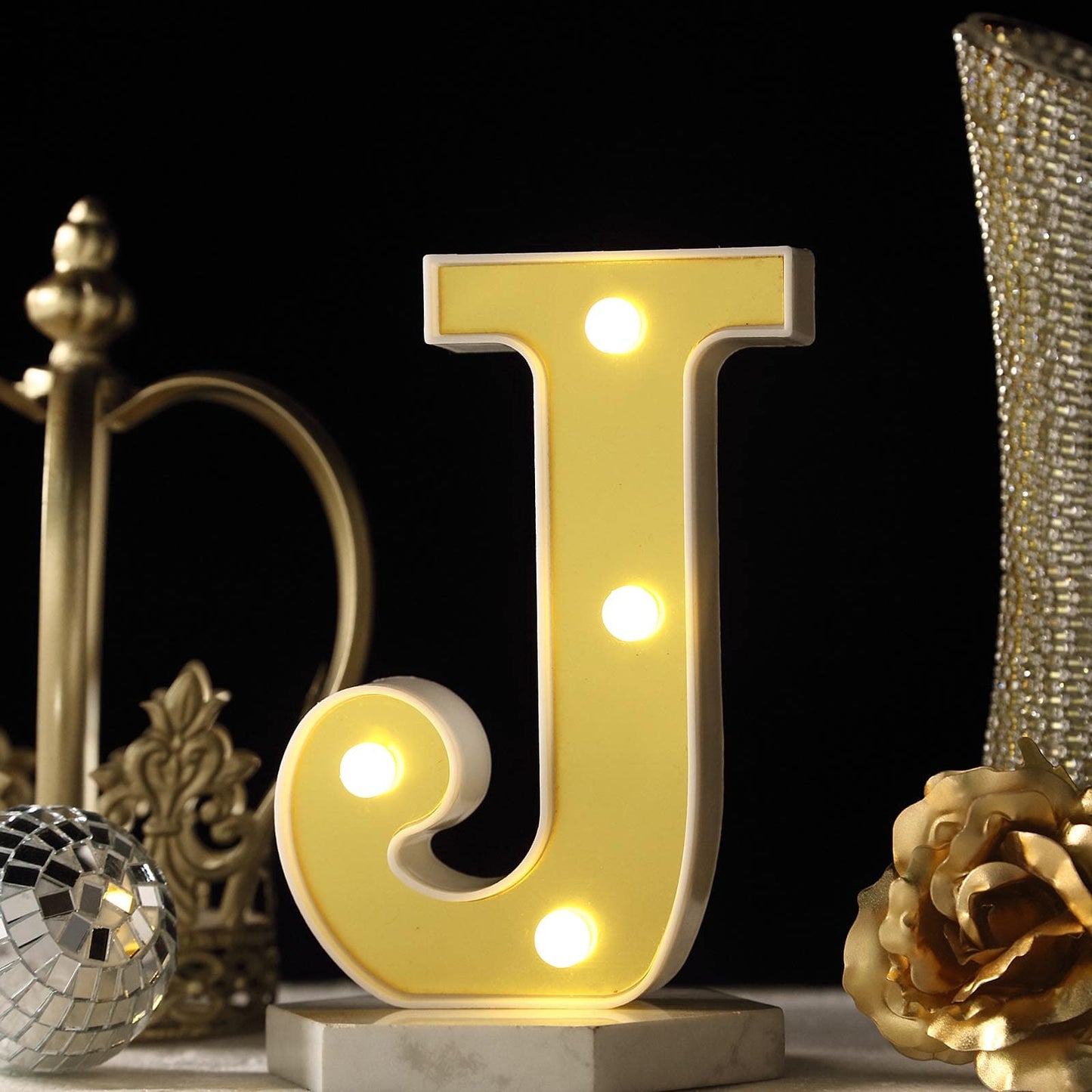 Gold 3D marquee letter "J" with warm white LED lights.
