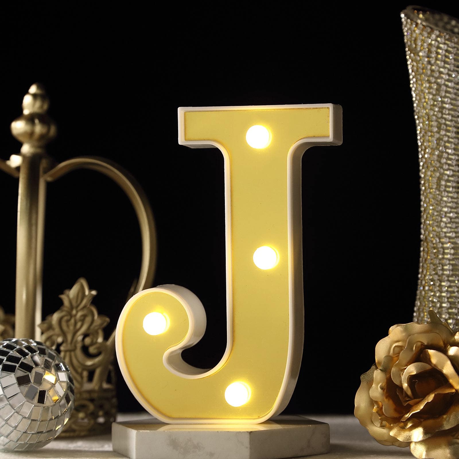 Gold 3D marquee letter "J" with warm white LED lights.