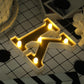 Gold 3D marquee letter "K" with warm white LED lights.