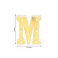 Gold 3D marquee letter "M" with warm white LED lights.