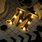 Gold 3D marquee letter "M" with warm white LED lights.