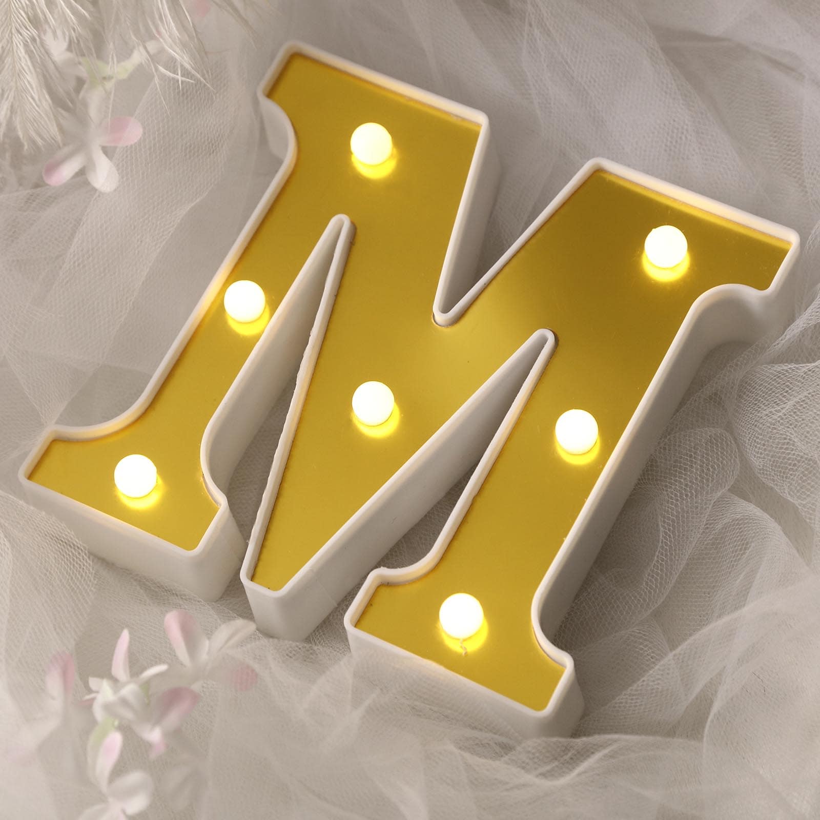 Gold 3D marquee letter "M" with warm white LED lights.