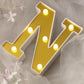 Gold 3D marquee letter "N" with warm white LED lights.