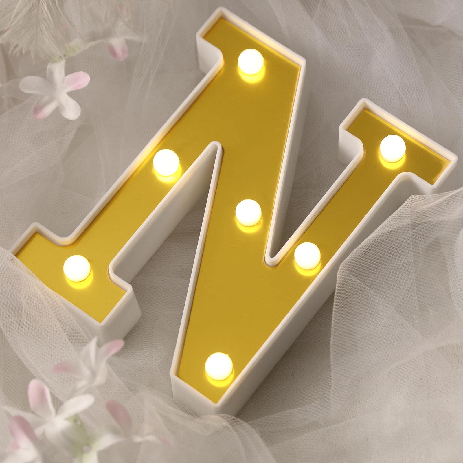 Gold 3D marquee letter "N" with warm white LED lights.