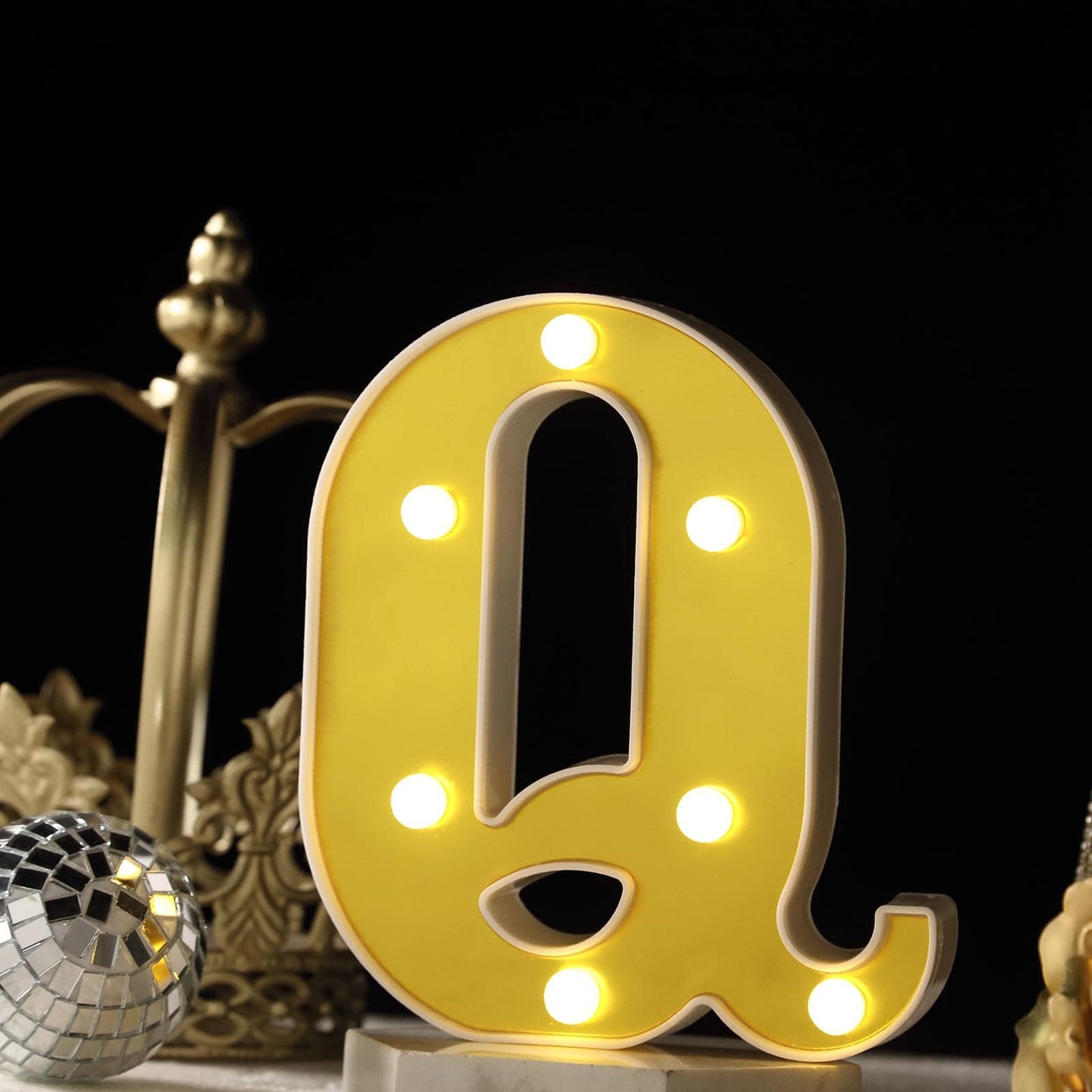 Gold 3D marquee letter "Q" with warm white LED lights.