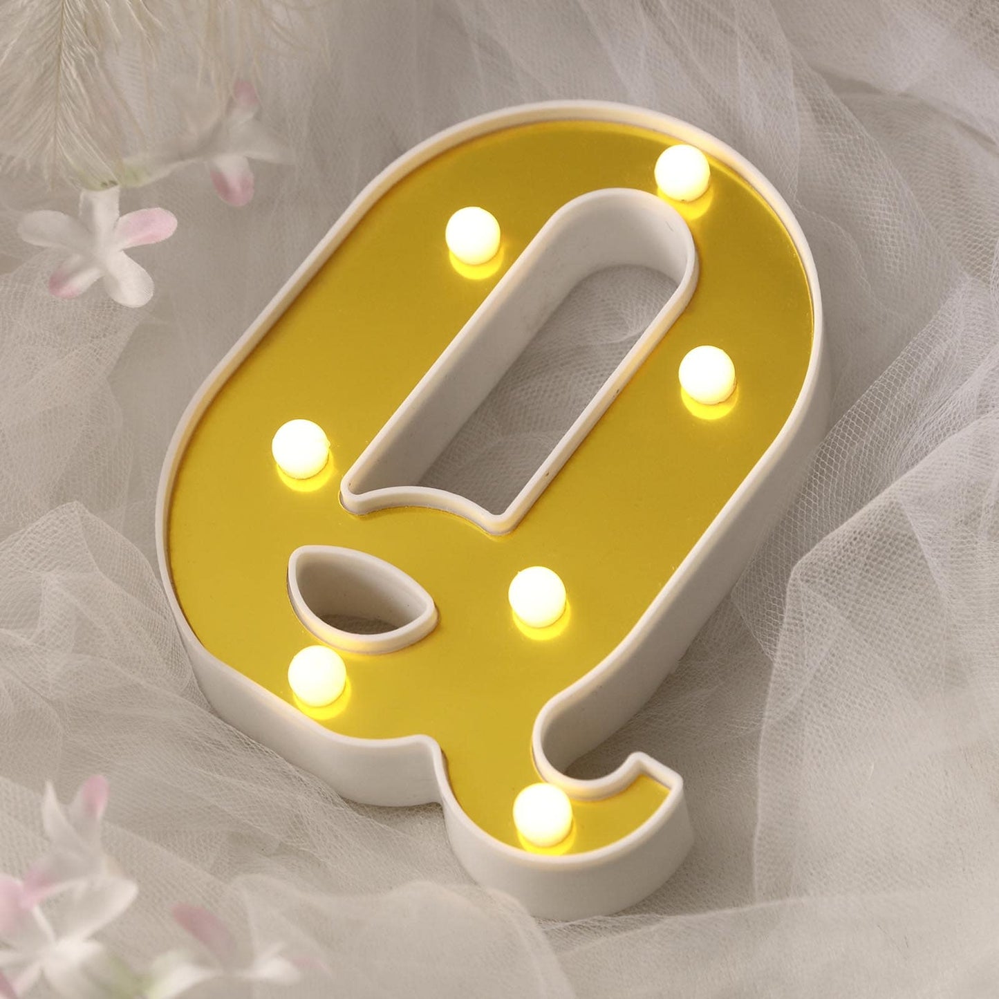 Gold 3D marquee letter "Q" with warm white LED lights.