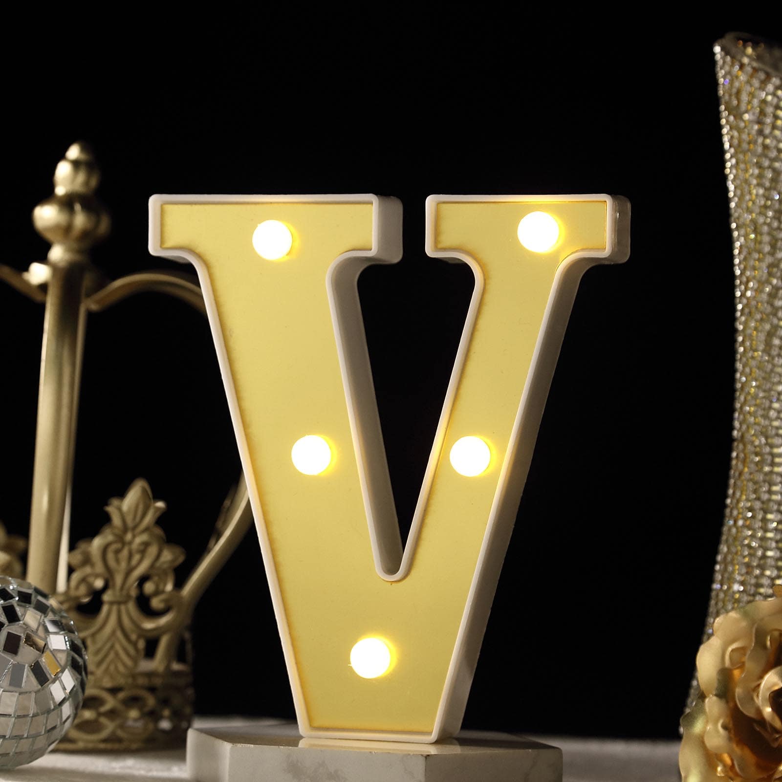 Gold 3D marquee letter "V" with warm white LED lights.
