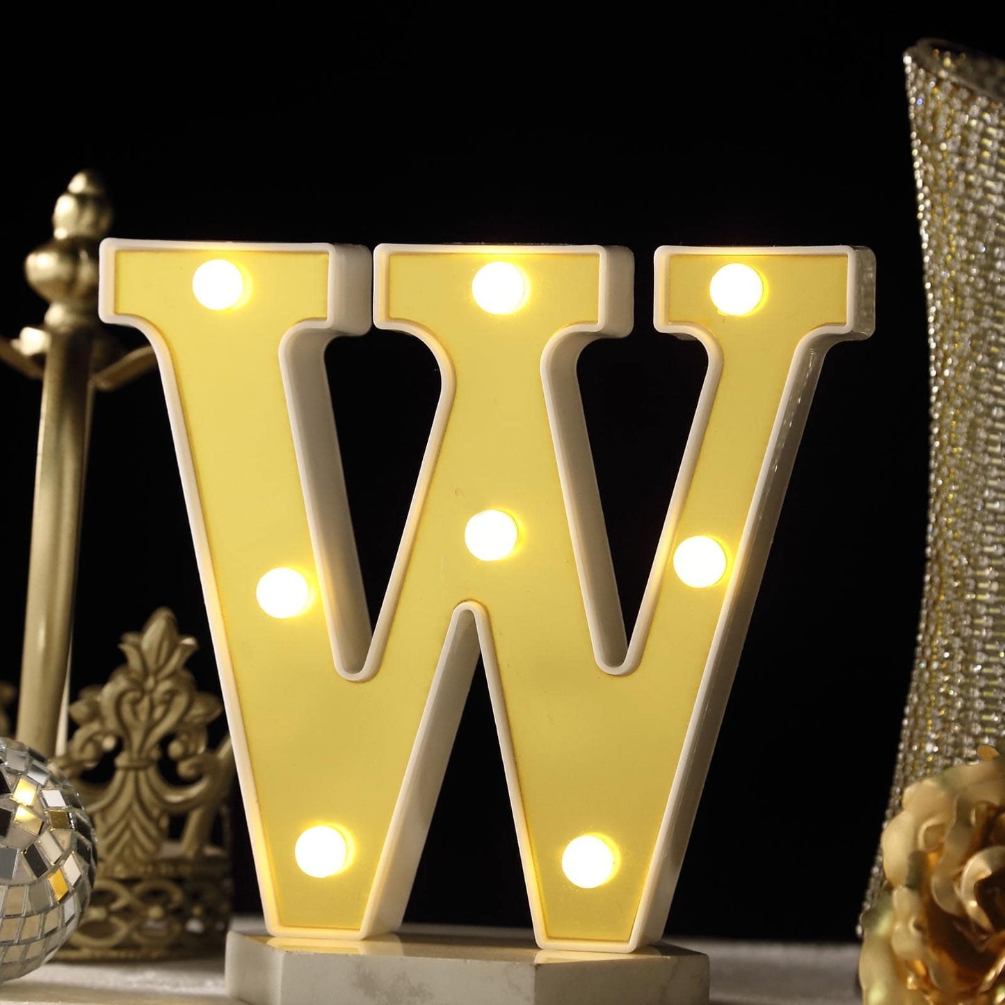 Gold 3D marquee letter "W" with warm white LED lights.
