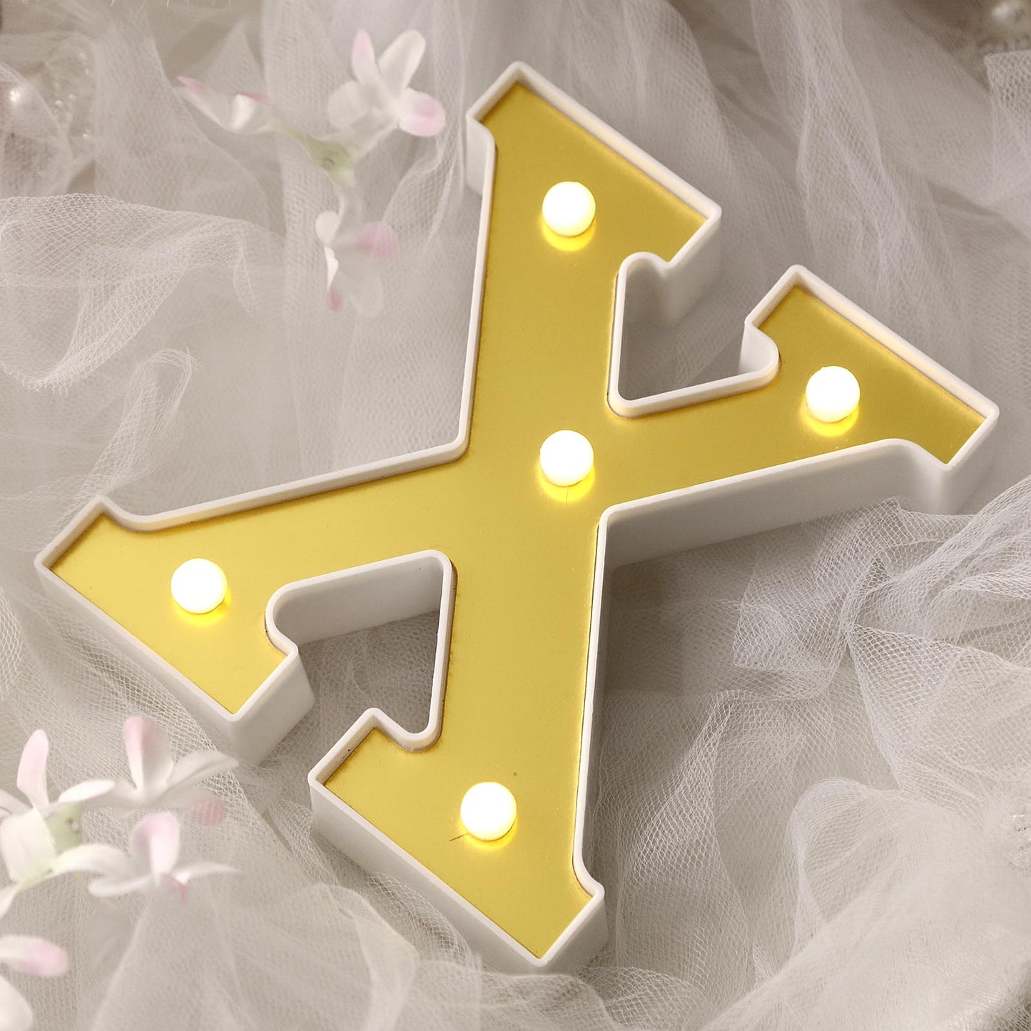 Gold 3D marquee letter "X" with warm white LED lights.