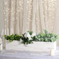 White rectangular wood planter box set with greenery and flowers.