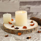 Rustic natural wood slice table centerpiece with candles and dried petals.