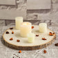 Natural color round rustic wood slice with candles and petals.