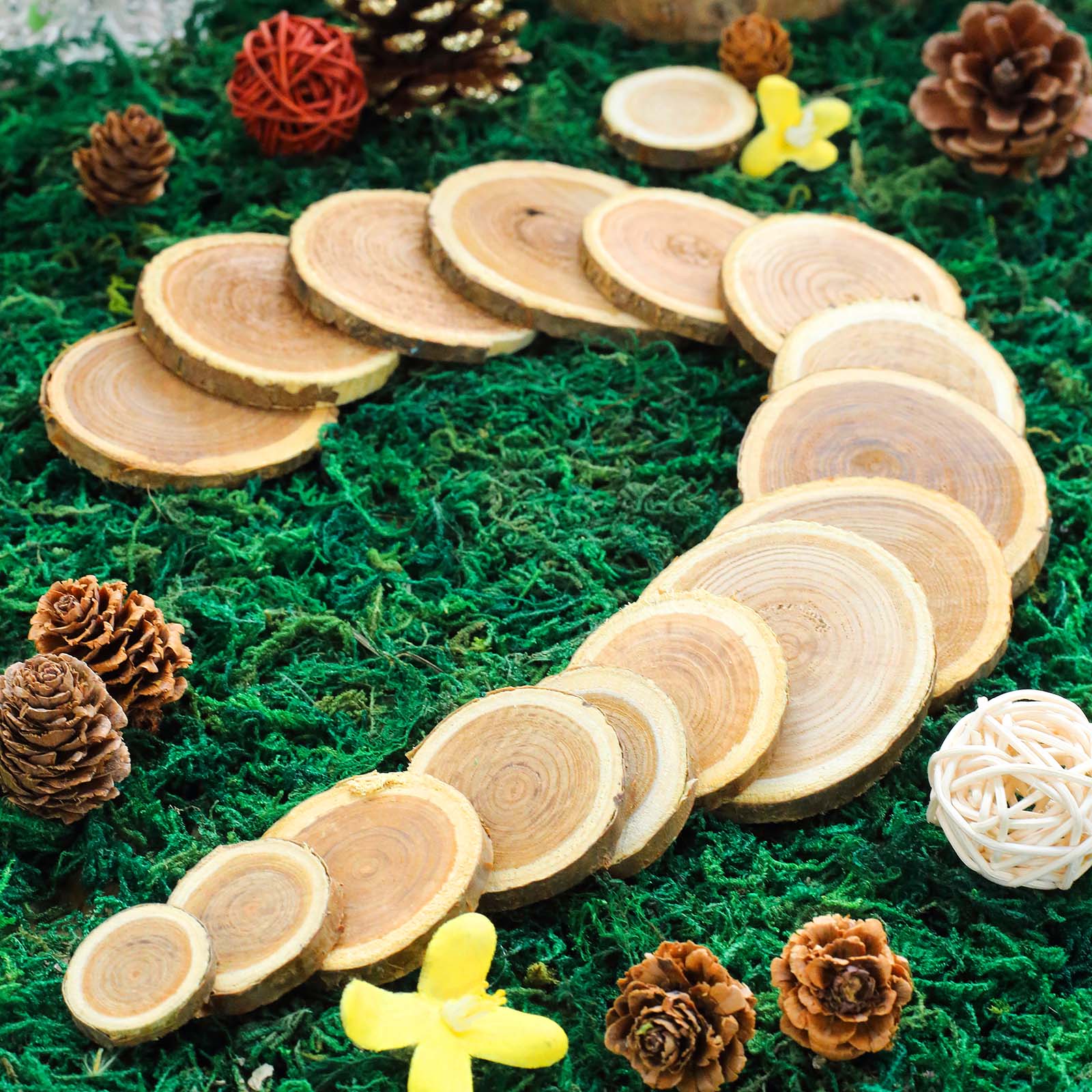Rustic cedar wood slices for wedding table scatters on green moss.