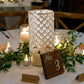 Gold crystal beaded pillar candle holder set on a decorated table.